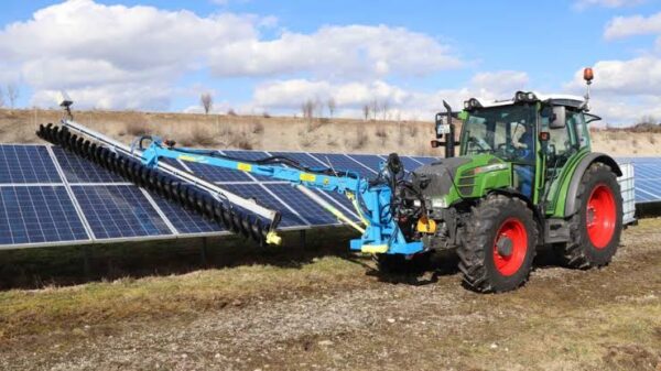 Tractor mounted solar panel cleaner